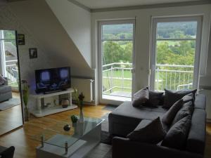 sala de estar con sofá y TV en Gäste Domizil Edel Zeit, en Allenbach