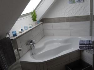 een badkamer met een ligbad en een wastafel bij Gäste Domizil Edel Zeit in Allenbach