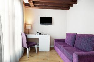 ein Wohnzimmer mit einem lila Sofa und einem Tisch in der Unterkunft Exe Paris Centre in Paris