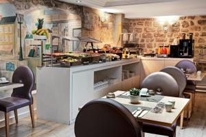 パリにあるExe Paris Centreのテーブルと椅子のあるレストラン、キッチンが備わります。