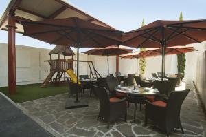 a restaurant with tables and chairs and umbrellas at Fiesta Inn Puebla Finsa in Puebla