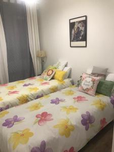 Un dormitorio con dos camas con flores. en Casa Jardín, en Logroño