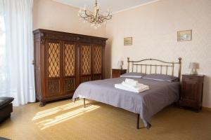 a bedroom with a bed and a chandelier at Bed & Roses Meni in La Morra