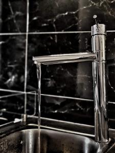 a metal sink with water coming out of a faucet at Meteora House- Cozy Living in Kalabaka +26 photos