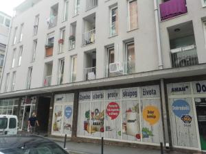 a white building with signs on the side of it at Apartman Centar 1 in Užice