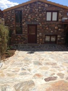 a stone house with a stone patio in front of it at Casa Do Quelho in Janeiro de Cima