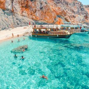 un barco en el agua junto a una playa en Adrasan La Casita Hotel, en Adrasan