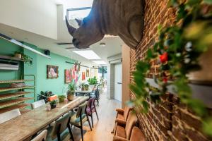 a restaurant with a long table with a rhino head on the wall at BareFoodGIULIA - Inspiration Hotel in Hasselt