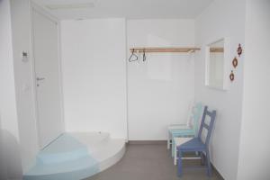 a room with a blue chair and a glass door at Cocor Suites & Design in Naples
