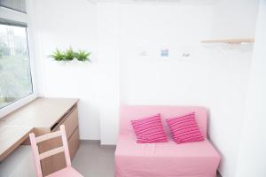 a pink couch with two pink pillows in a room at Cocor Suites & Design in Naples