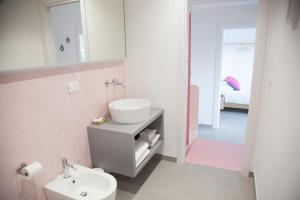 a pink bathroom with a sink and a toilet at Cocor Suites & Design in Naples +37 photos