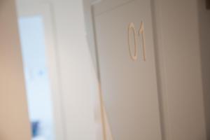 a white door with a clock on the side of it at Cocor Suites & Design in Naples