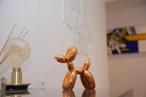 una statua d'oro di un cane su un tavolo accanto a una lampadina di Cocor Suites & Design a Napoli