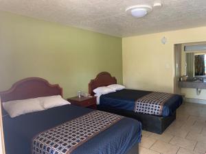 um quarto de hotel com duas camas e uma janela em Texas Inn Beaumont em Beaumont