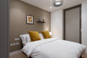 a bedroom with a white bed and white walls at Mirabilis Apartments - Bayham Street in London