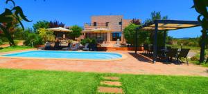een zwembad in een tuin met stoelen en een huis bij Son Vigili in Campos
