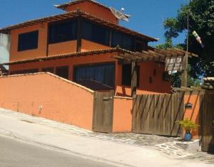 a house with a fence in front of it at Biruta Guest House in Búzios