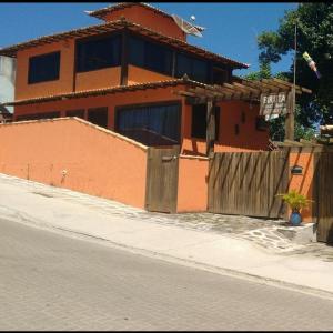 a house on the side of a street with a fence at Biruta Guest House in Búzios