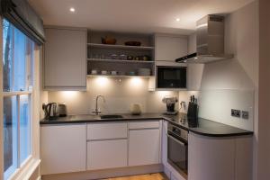 a kitchen with white cabinets and a sink and a window at Waterloo Sunset in London