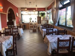 un restaurante con varias mesas y sillas y una sala llena de mesas y sillas en Albergo Antica Luni en Luni