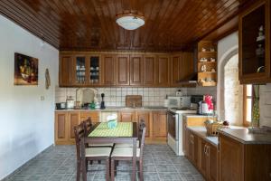 a kitchen with wooden cabinets and a table with chairs at Villa Tzaniana in Apomarmá