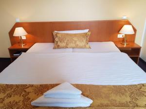 a bedroom with a bed with two lamps and towels on it at Hotel La Musica in Glessen