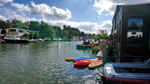 a river with boats in the water next to a building at Houseboat Vliegenbos in Amsterdam