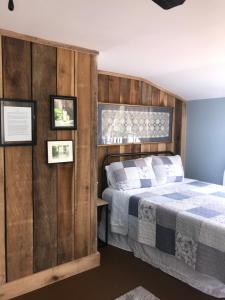 um quarto com uma cama e uma parede de madeira em Riverboat Bed & Breakfast em Natchez