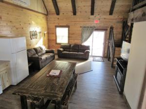 a living room with a couch and a table at Freedom Ridge Cabins in Hill City