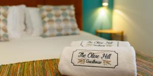 a hotel room with a bed with towels on it at The Olive Hill Guesthouse in Batalha