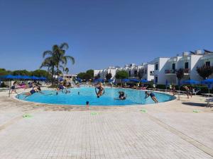 a group of people playing in a swimming pool at Hotel Resort Portoselvaggio in Sant'Isidoro