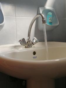 a sink with water running from a faucet at Ionio Sea Poros Studios in Mikros Gialos