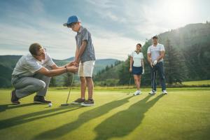 grupa ludzi grających w golfa na polu golfowym w obiekcie High Ceilings, Natural Light- 3 Bedroom Arrowhead Village Condo w mieście Beaver Creek