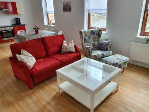 a living room with a red couch and a coffee table at Ferienwohnung Muldental in Grimma