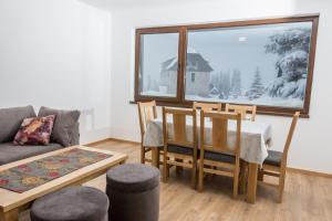 a living room with a table and a couch at Villa San in Jahorina