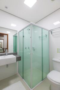 La salle de bains est pourvue d'une douche en verre et de toilettes. dans l'établissement Villa Rio Branco Hotel Concept, à Rio Branco