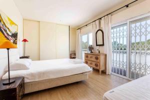 Un dormitorio con dos camas y una gran ventana. en Luxury Villa 6 bedrooms with private pool, en Vilamoura