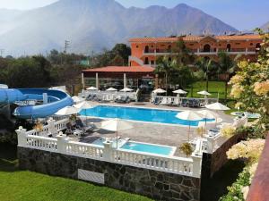een resort met een zwembad en een gebouw bij Lunahuana River Resort in Lunahuaná