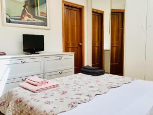 a bedroom with a bed with a dresser and a television at Casa Santo Stefano in Bologna