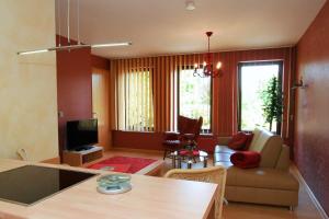Landhaus Hof-Schlenstedt في شتاتالندورف: غرفة معيشة مع أريكة وغرفة طعام