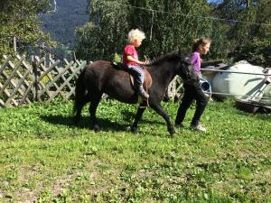 Una ragazza che cavalca un cavallo con una donna di Pirchachhof a Wenns