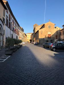 een geplaveide straat in een stad met geparkeerde auto's bij Le case di Nonna Gina in Capranica