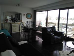 a living room with a couch and a table and chairs at Residentie Aldis met 1 slaapkamer in Ostend