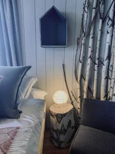 a bedroom with a bed and a tree stump with a lamp at Hôtel Le Grand Chalet Favre in Saint-Luc