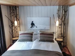 a bedroom with a bed and a picture of a bird at Hôtel Le Grand Chalet Favre in Saint-Luc