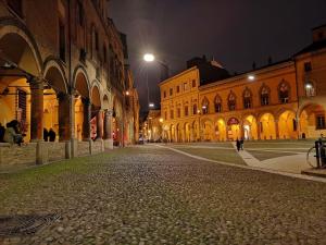 una calle de ciudad vacía por la noche con edificios en Casa Santo Stefano, en Bolonia