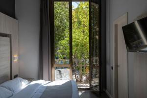 a bedroom with a bed and a view of a balcony at Plaza Goya Rooms in Barcelona