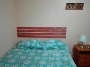 a bedroom with a bed with a wooden headboard at Donde Lupe in Coihaique