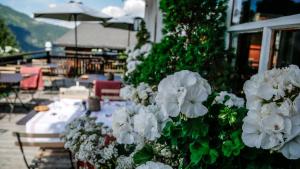 a table with white flowers in front of a building at Hôtel Le Grand Chalet Favre in Saint-Luc