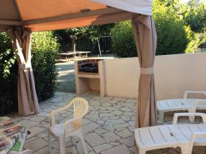 patio z krzesłami i altaną w obiekcie gîte la source milieu w mieście Vias